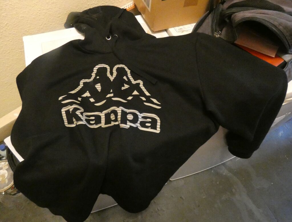 Jugendserie Göttingen 2024, liegengebliebener schwarzer Hoodie mit der Aufschrift “Kappa“.